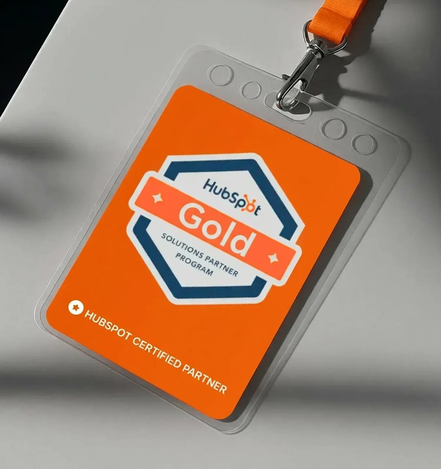 HubSpot Gold Solutions Partner badge on orange ID card with lanyard showing certified partner program credential